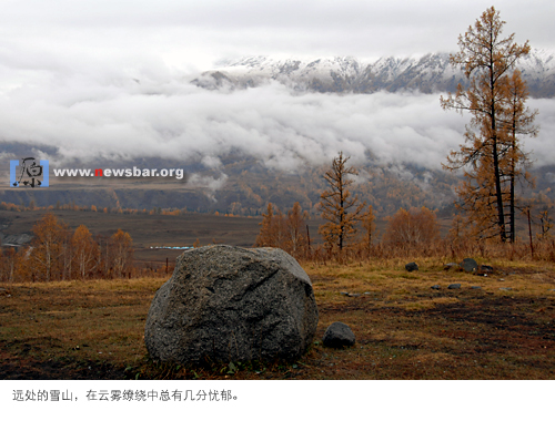 新疆禾木，远处的雪山在云雾缭绕中透出几分忧郁。