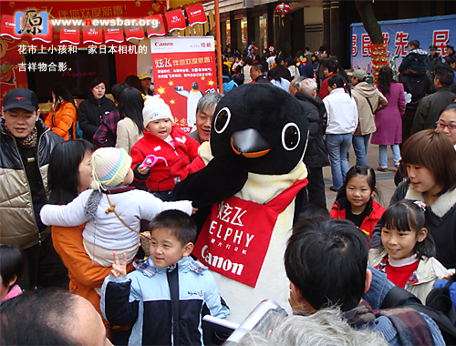 2008年2月6日广州教育路西湖路中心花市，小孩和一家日本相机公司的吉祥物合影。